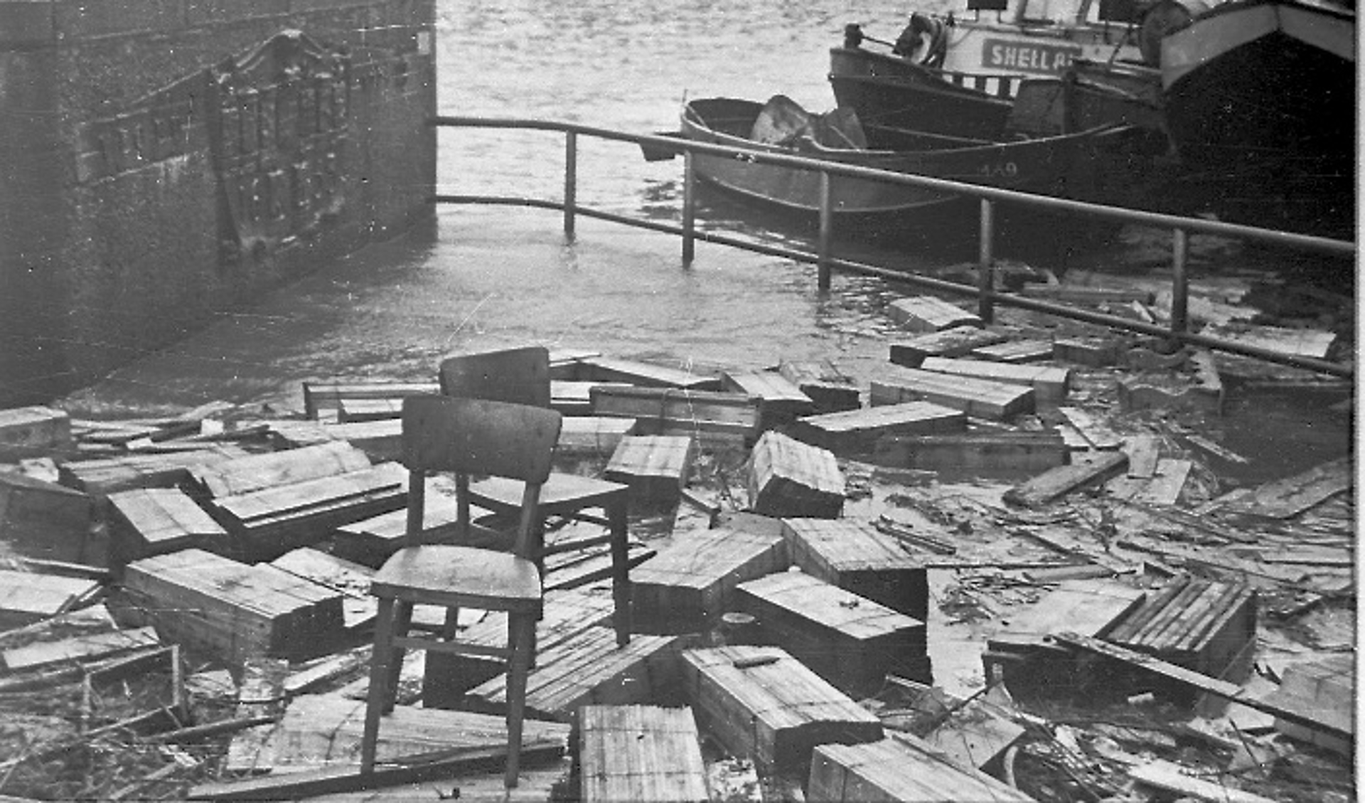 Ravage na de storm van 1 februari 1953 op de Stadhuiskade bij de Wateringsche Sluis. Al het hout van de kistenfabriek was weggespoeld en overal in het overstroomde gebied was het terug te vinden. 