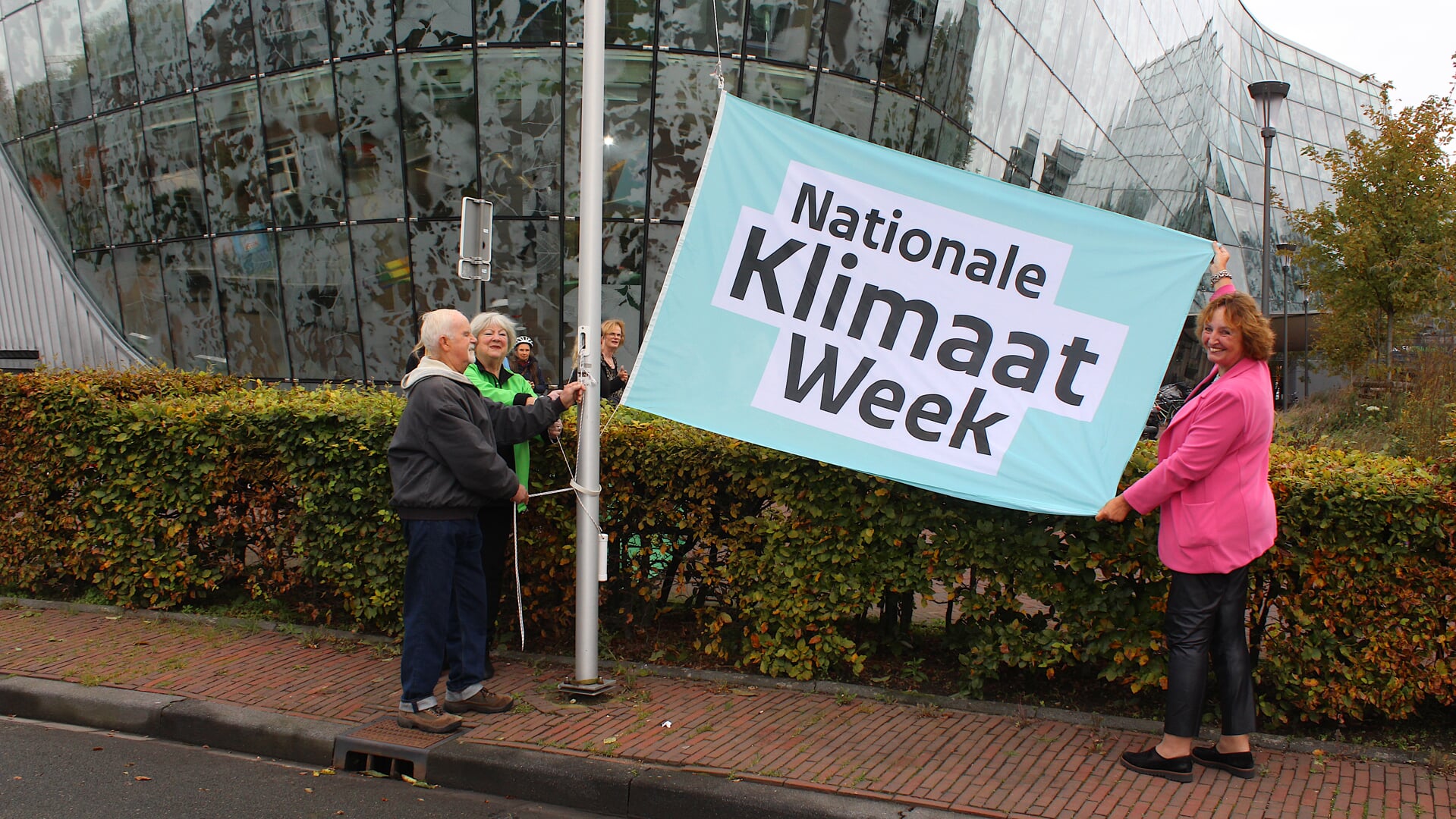 In Alphen wordt de klimaatvlag gehesen door burgemeester Liesbeth Spies (r) en klimaatburgemeesters Hans van Dam en Wilma Gerver.