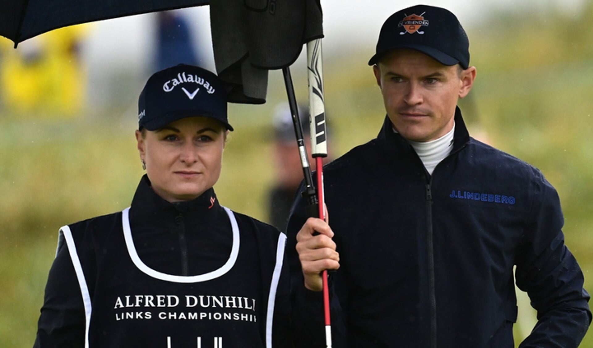 Daan Huizing schuilt met vrouw en caddie Daniëlle onder een grote paraplu tijdens het Dunhill Links Championship. (Foto Golfsupport.nl)