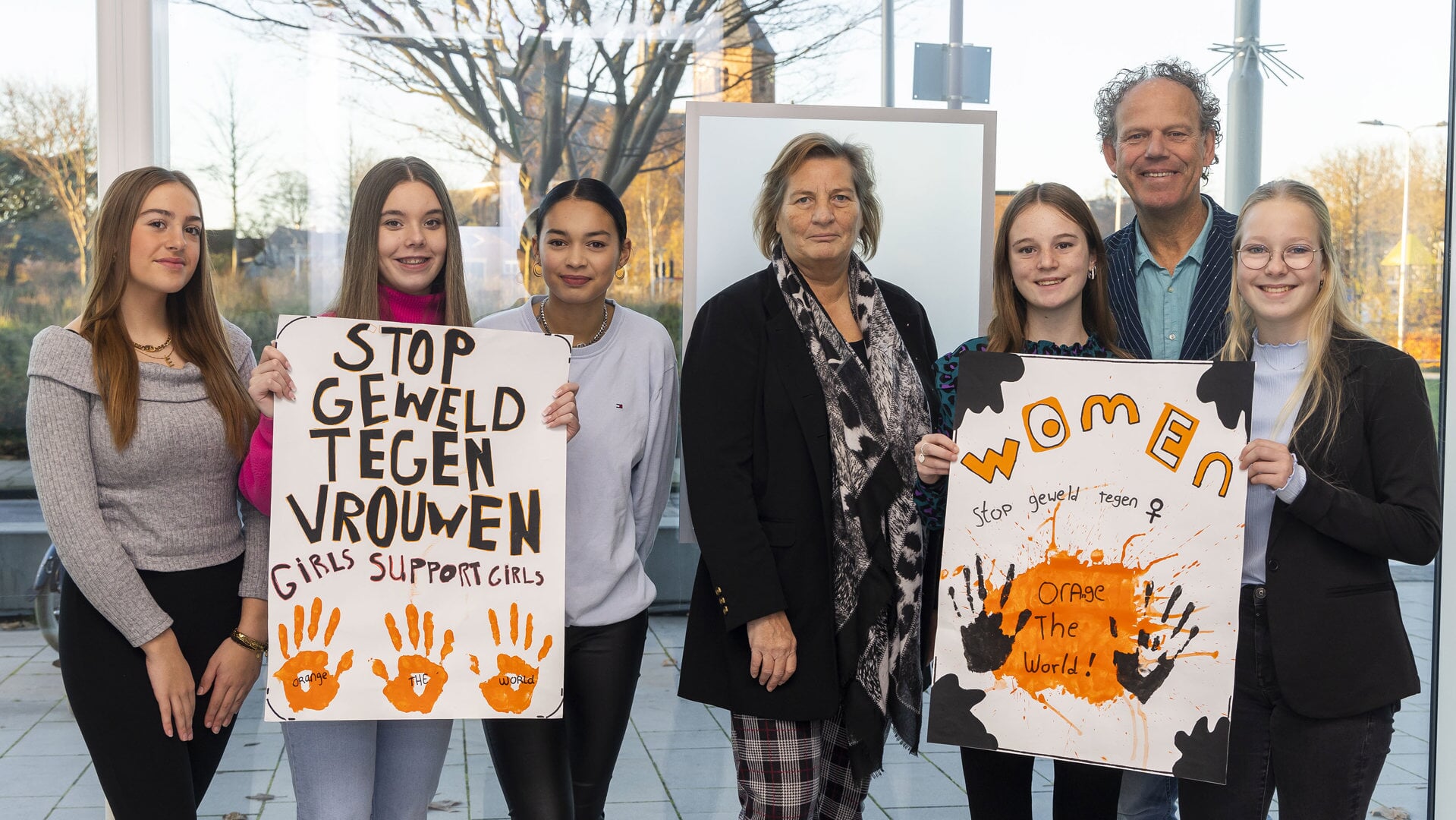 Wethouder Carlieke van Staalduinen met docent Martin Groen en enkele leerlingen van het Lentiz met posters voor Orange the World.