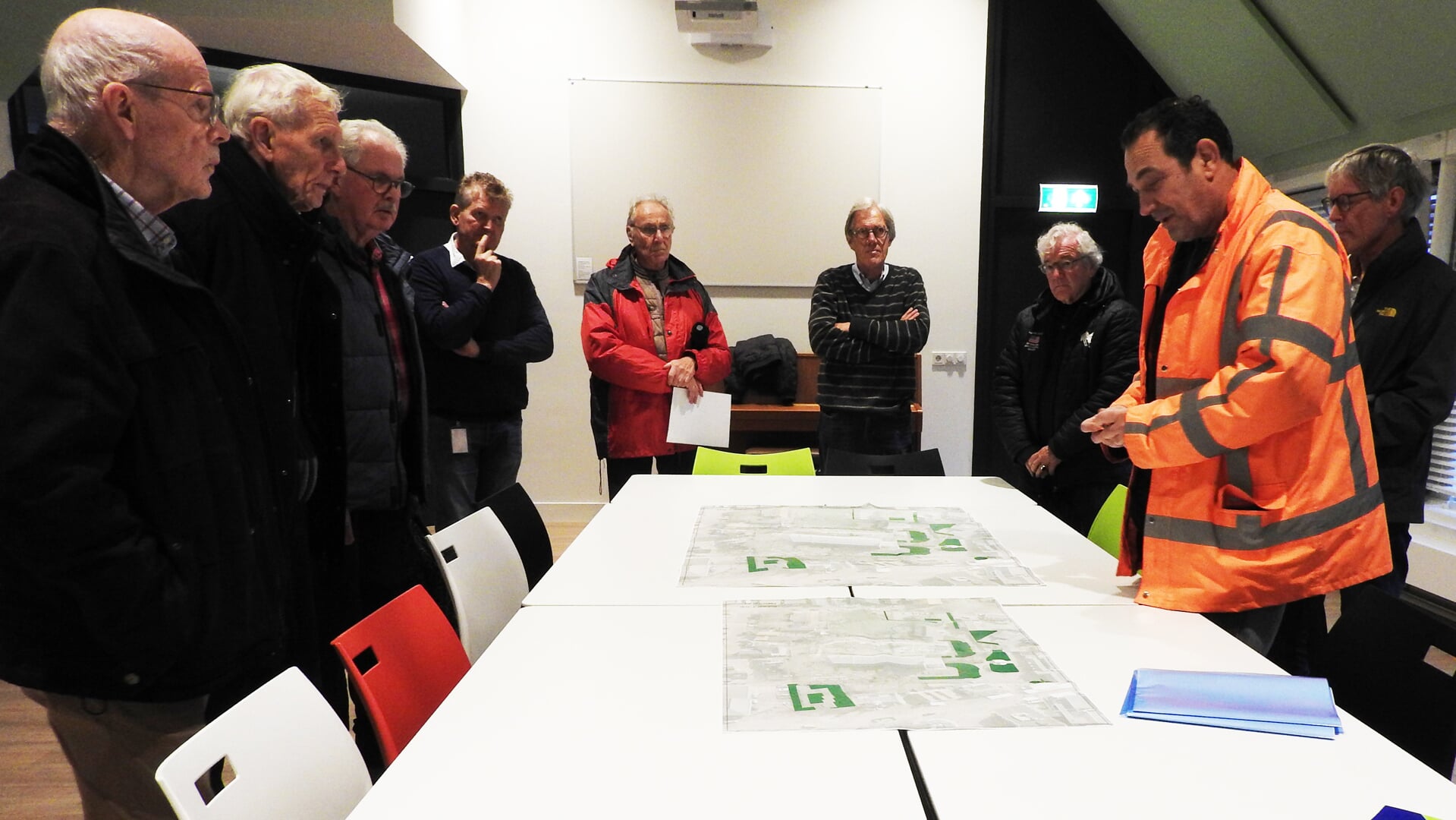 Projectleider Corne van Steen, in reflectiejas, geeft aan de hand van tekeningen een uitleg over de plannen.