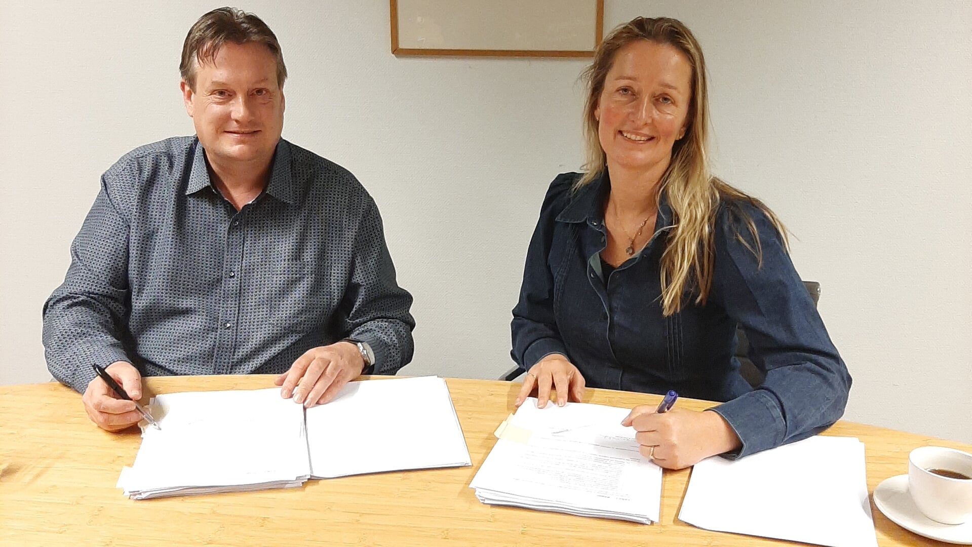 Piet-Jan Ooms, directeur van Ooms Bouw & Ontwikkeling en wethouder Rosalien van Dolder van de gemeente Koggenland ondertekenen de anterieure overeenkomst.
