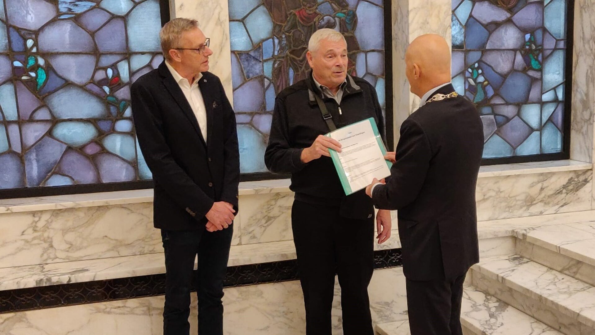 Burgemeester Wijbenga ontvangt de petitie “Herbezinning Drevenbuurt aardgasvrij” uit handen van Henk Maarleveld en Hans de Wid.