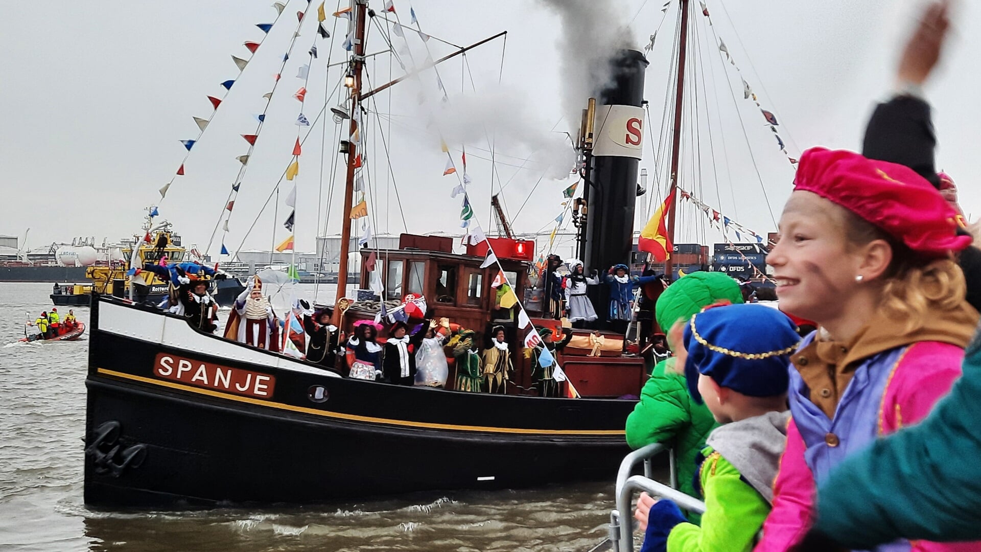 De stoomboot Spanje draait met Sinterklaas op de voorsteven de Buitenhaven in om even later onder grote belangstelling af te meren in de Oude Haven naast de Visbank.