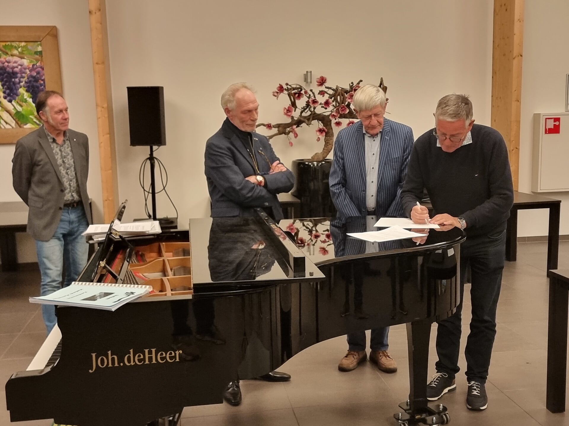 Pianist Martin van Broekhoven, dirigent Hans de Wit, penningmeester Henk van Trigt en voorzitter Arie Strijbis van het Westlands Mannenkoor verlengen de contracten. 