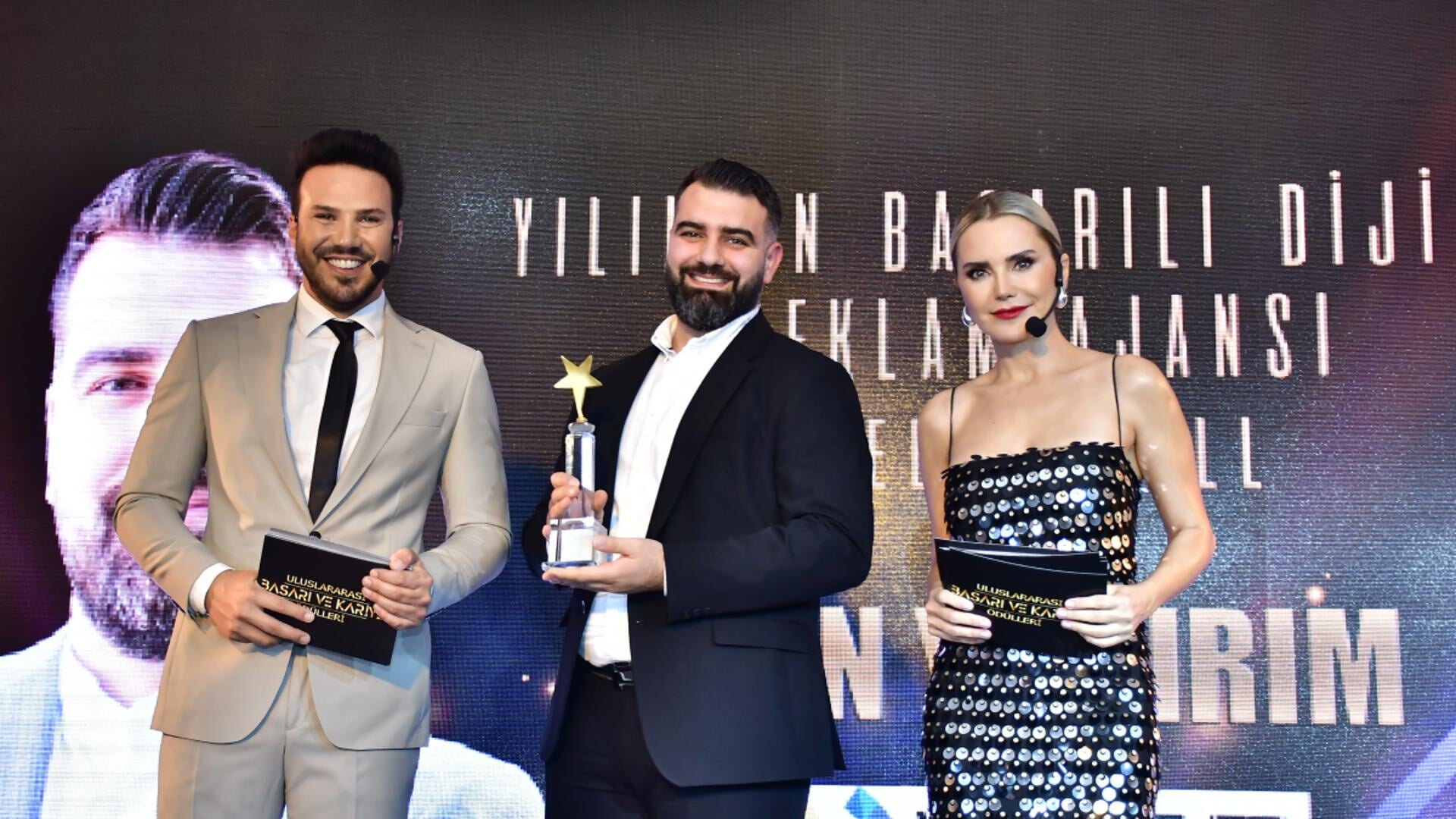 Yasin Yildirim (midden) krijgt de prijs uitgereikt. 