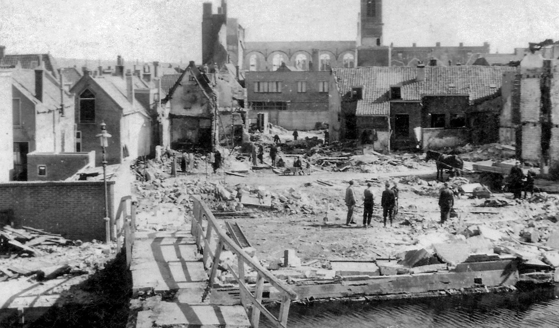 De gevolgen van het bombardement op 18 maart 1943 gezien vanaf de Noorddijk richting Wagenstraat. Op de achtergrond de restanten van de Noorderkerk. Op de voorgrond de Karnemelkbrug.