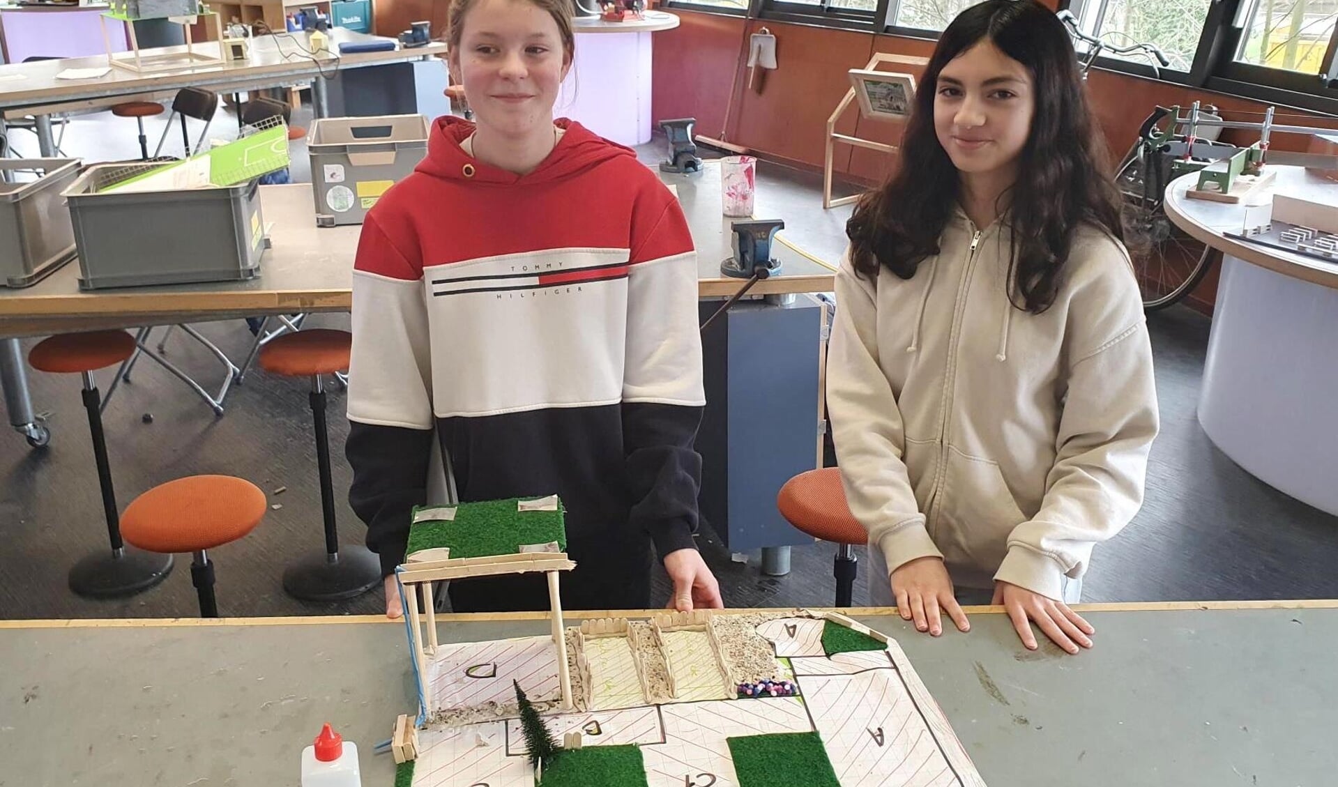 Technasiumleerlingen Madelon (links) en Lamia (rechts) tonen trots de maquette van hun klimaatbestendige schoolplein voor scholengemeenschap Spieringshoek.