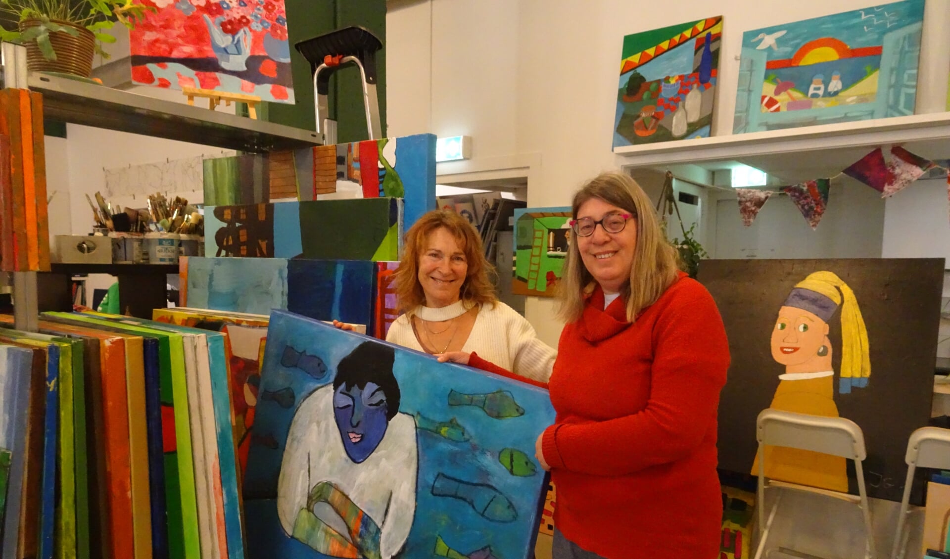 Marianne (links) en Sofie tonen het schilderij dat straks, samen met nog 14 andere kunstwerken, te zien zal zijn op de Paasexpositie van de Lichtkring.