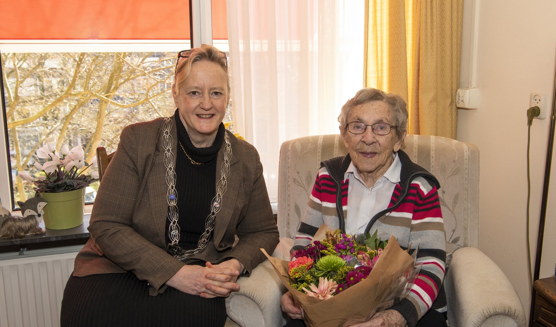 Locoburgemeester Antoinette Laan feliciteert 101-jarige mevrouw Van Eijk-Klapwijk, en overhandigt haar een prachtig boeket bloemen.