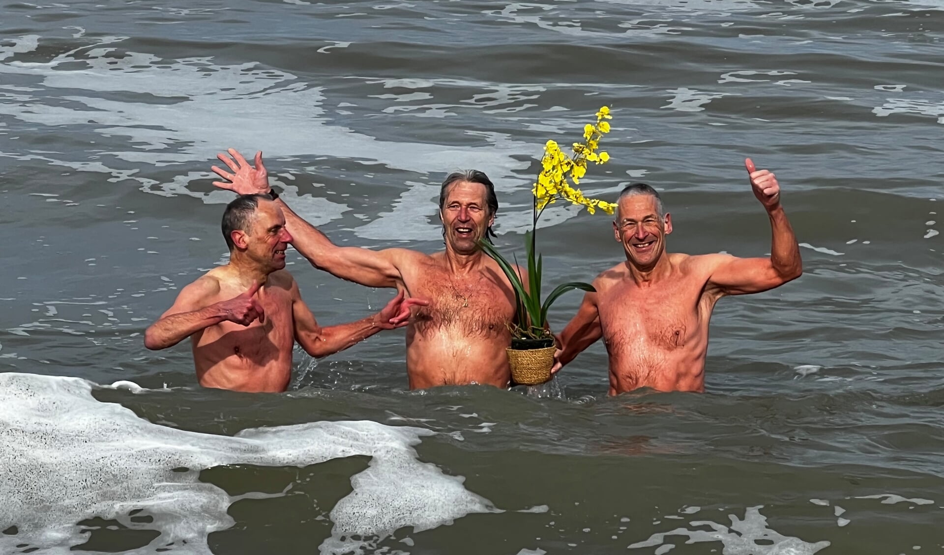 René van Dijk (midden), Henk Pape (rechts) en Fred Louter met een orchidee in zee.