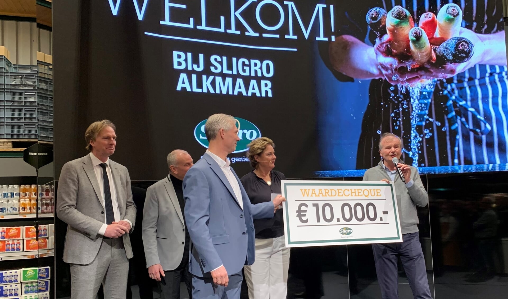 Sander Koolwijk (midden) van Sligro Alkmaar overhandigt de cheque aan Wim van der Ham (rechts). 