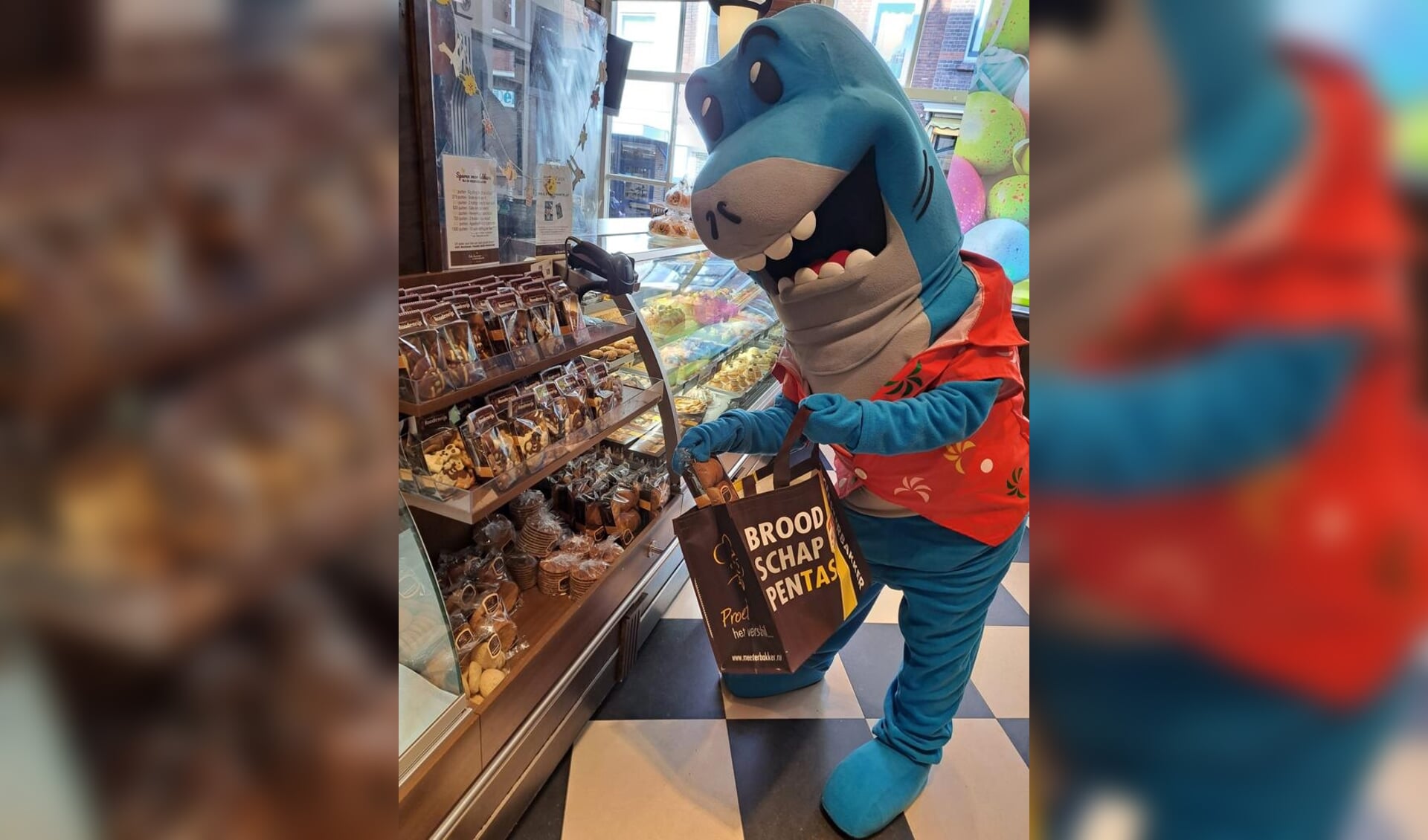 Optisport mascotte Zed de haai doet boodschappen bij Meesterbakker Remmerswaal-Roodenrijs.
