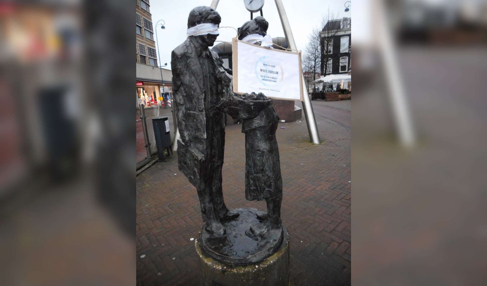 Bloemenmeisje met blinddoek en bord op het Verwulft in Haarlem.