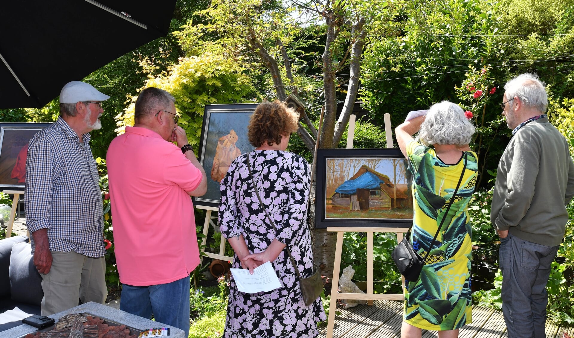 Deelnemers van de Kunstroute tonen trots hun kunstwerken.