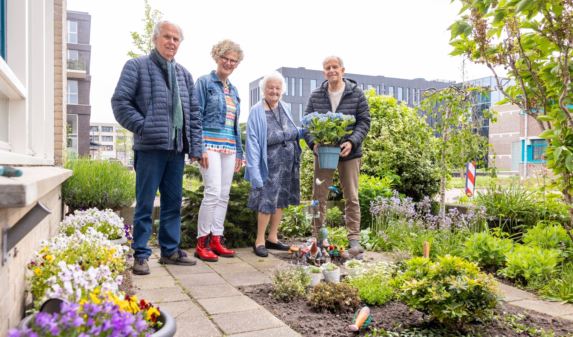 Een trotse mevrouw Meinen in haar opgeknapte tuintje, met naast haar vrijwilligers Klaas en Karin en Frits Weel, voorzitter van Gouden Dagen Heerhugowaard.