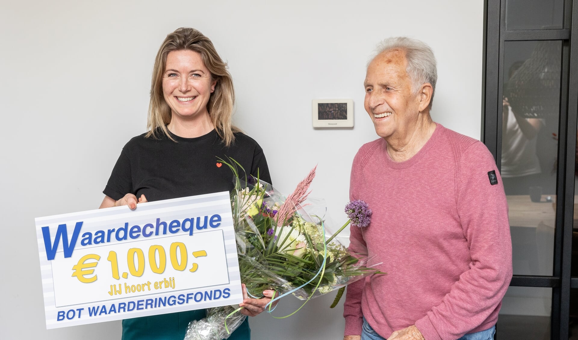 Siona Oosterkamp is blij verrast met de cheque die ze heeft gekregen van Frits Weel, voorzitter van het Bot Waarderingsfonds.