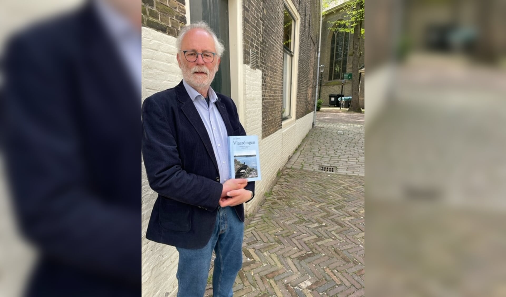 Arie de Klerk met zijn nieuwe boek in de Smalle Havenstraat, een van de oudste straten van Vlaardingen.