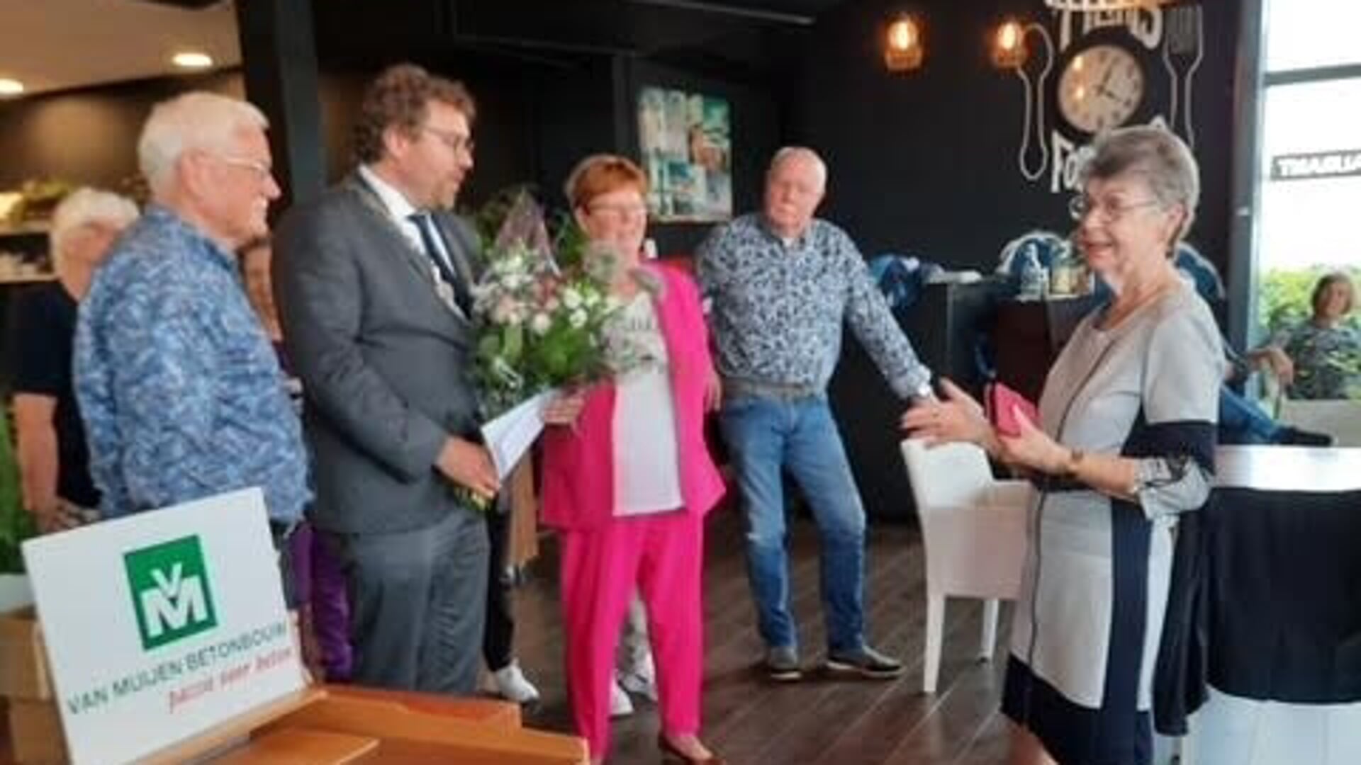 Burgemeester Poorter reikte bloemen uit aan vrijwilligster en initiatiefneemster Reina Venema (r).