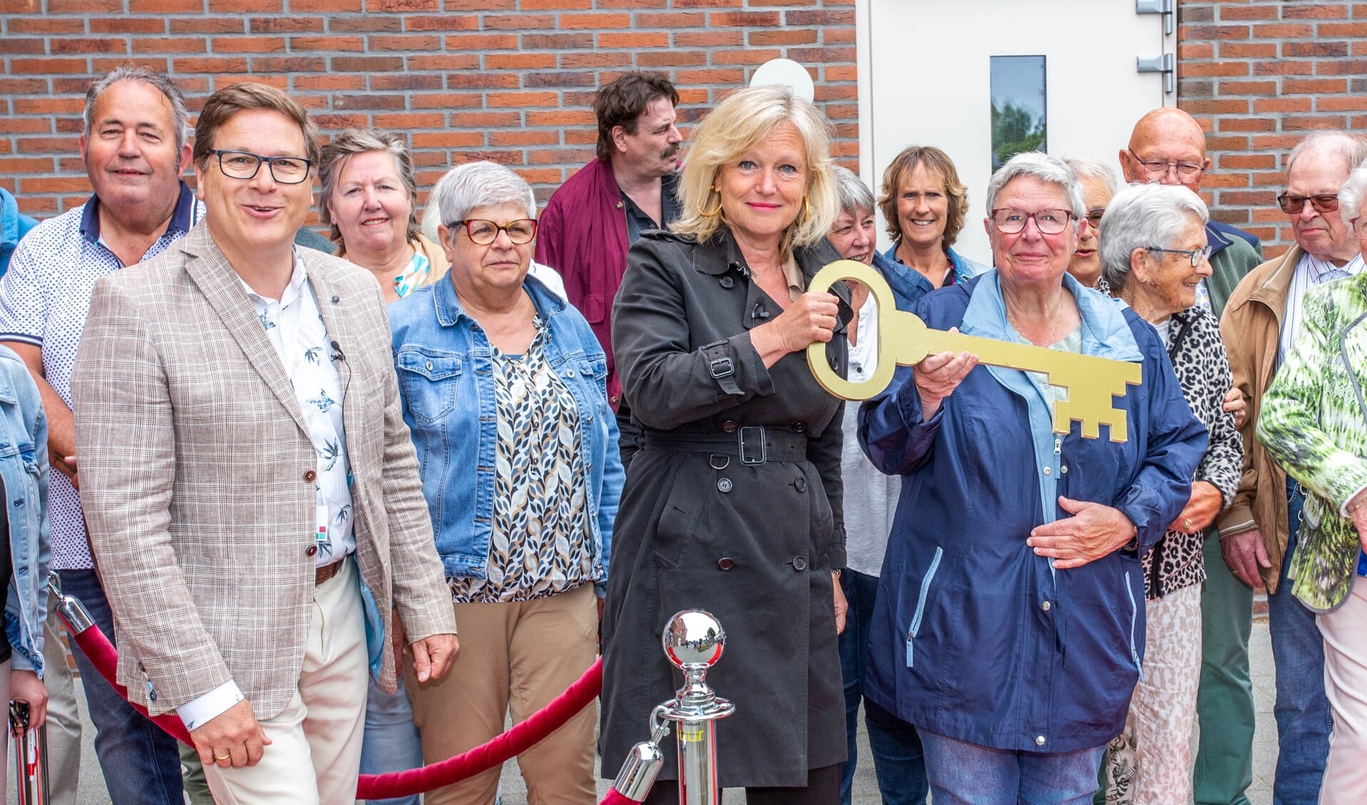 Wethouder Chantal Zeegers gaat met haar grote gouden sleutel Nieuw Welgelegen officieel openen. Links van haar staat tussen de bewoners Frans Desloover, directeur-bestuurder van Ressort Wonen. 