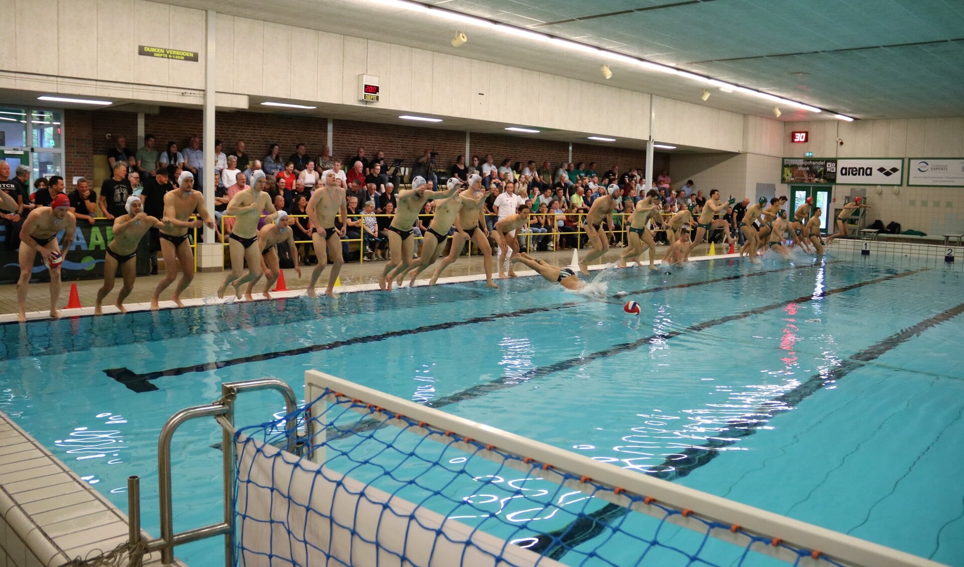 In een afgeladen zwembad De Slag duiken/springen de heren van Zv de Zaan en UZSC te water voor hun eerste duel in de halve finale om het NK.