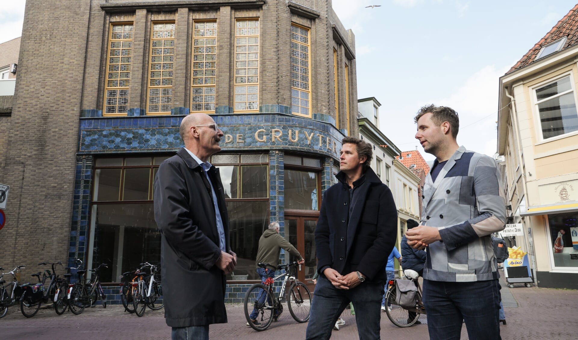 Eigenaar Freek van Waveren, wethouder Axel Boomgaars en Pieter Meijers van Erfgoed gemeente Hoorn zijn content met de samenwerking die heeft geleid tot het behoud van de mooie historische winkelgevel.  