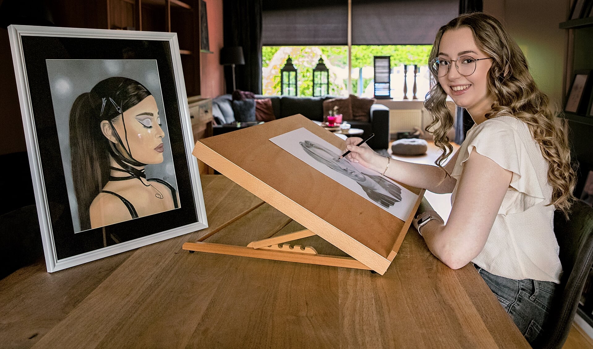 Britney achter haar tekentafel. Met op links een zeldzaam portret in kleur. 