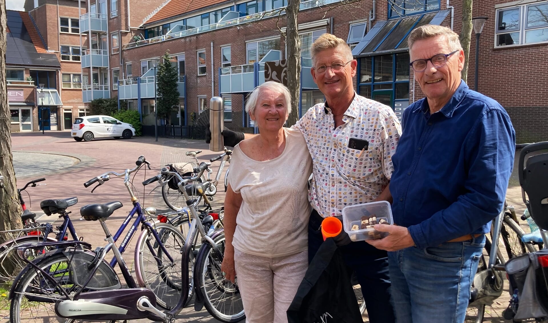 Buurtbewoonster Loes verzorgt fietsherstellers Kees Zonneveld en Gerard Castricum van een natje en een droogje.