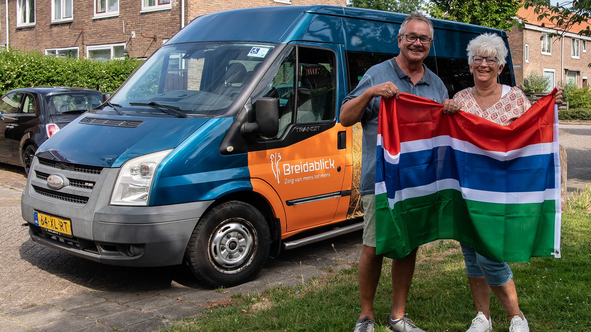Hans en Astrid met de bus en de Gambiaanse vlag.