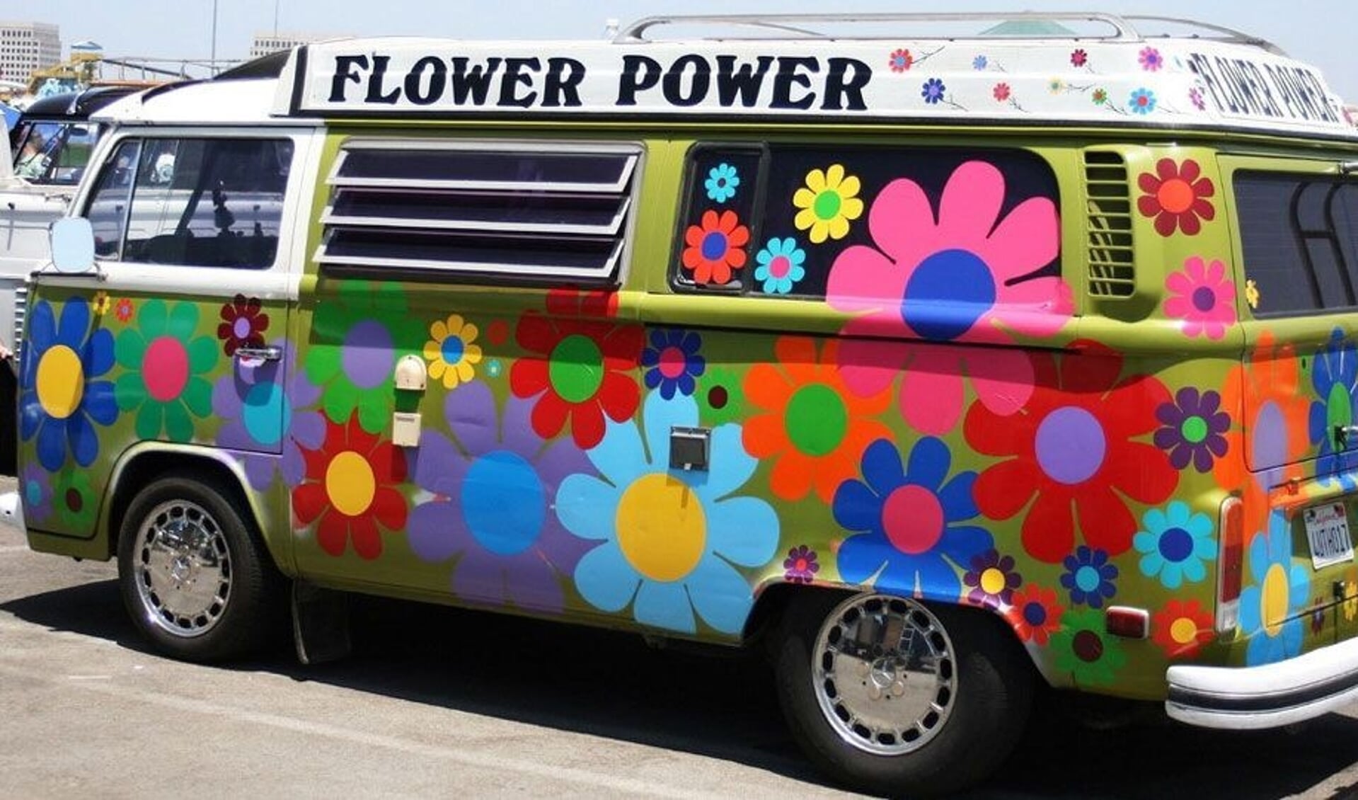 Op de voorkant van de boot komt een kleurrijk Volkswagenbusje en verder aankleding met onder andere grote peace-teken en het showteam in hippiekleding. 