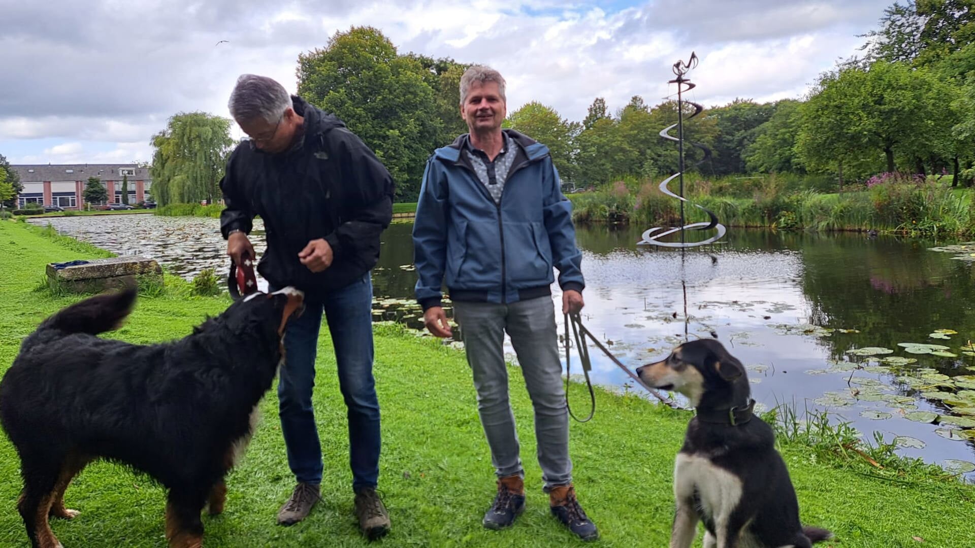 Wateringers Rob (links) en Jasper vinden de nieuwe fontein een hele verbetering ten opzichte van de vorige. Hun honden Ben (links) en Storm lijkt het niet veel uit te maken.