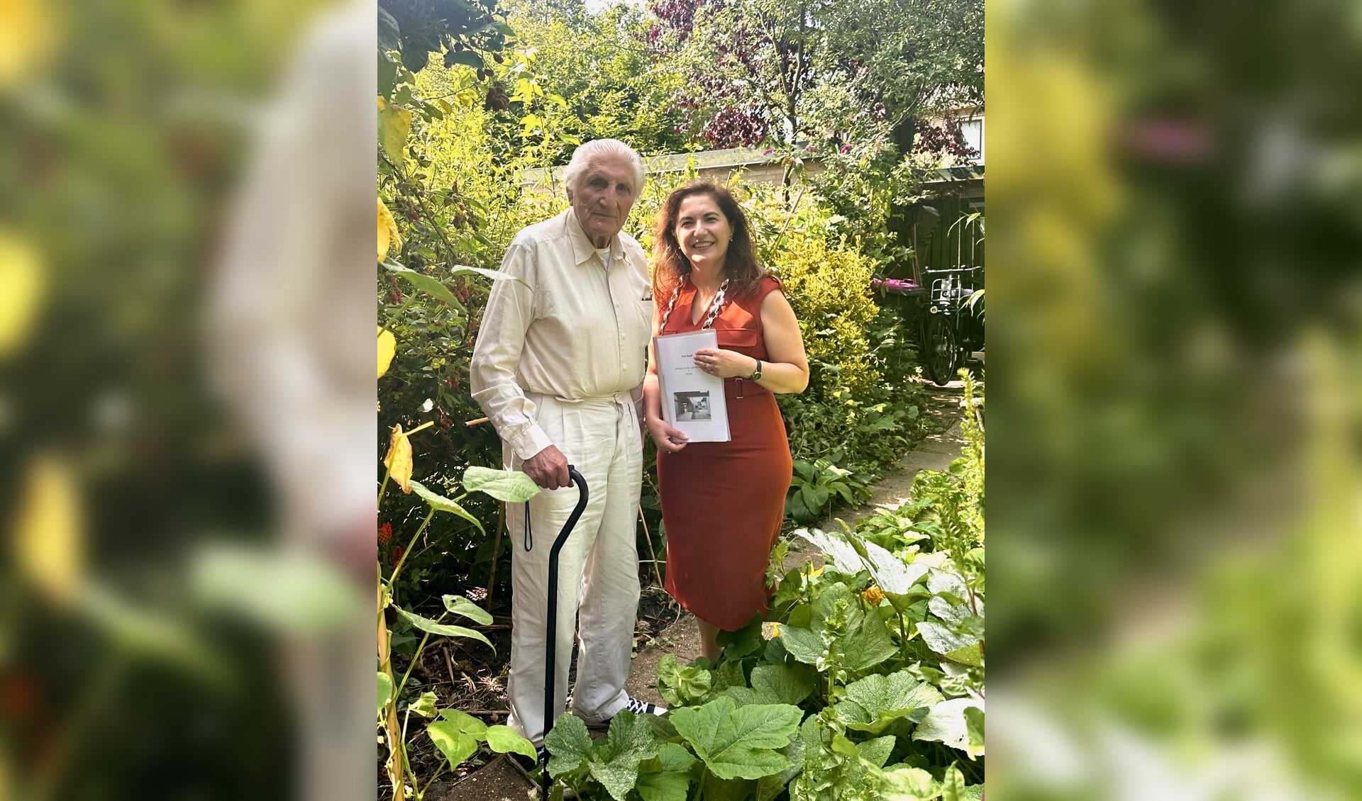 De 100-jarige André Klapwijk overhandigt zijn visie over seniorenwoningen aan burgemeester Huri Sahin.