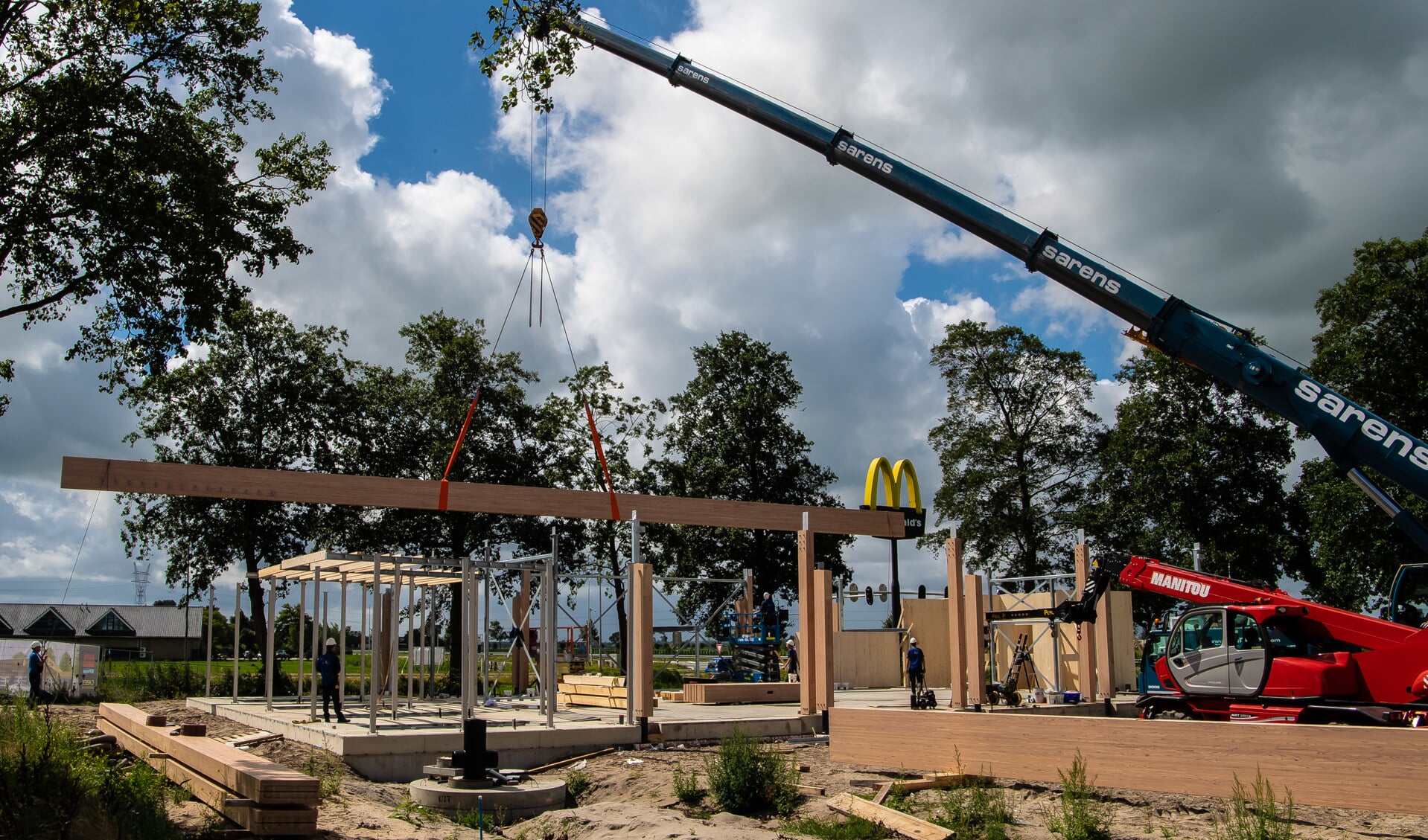 Een speciale hijskraan plaatst de 32 meter lange houten delen op hun plek.