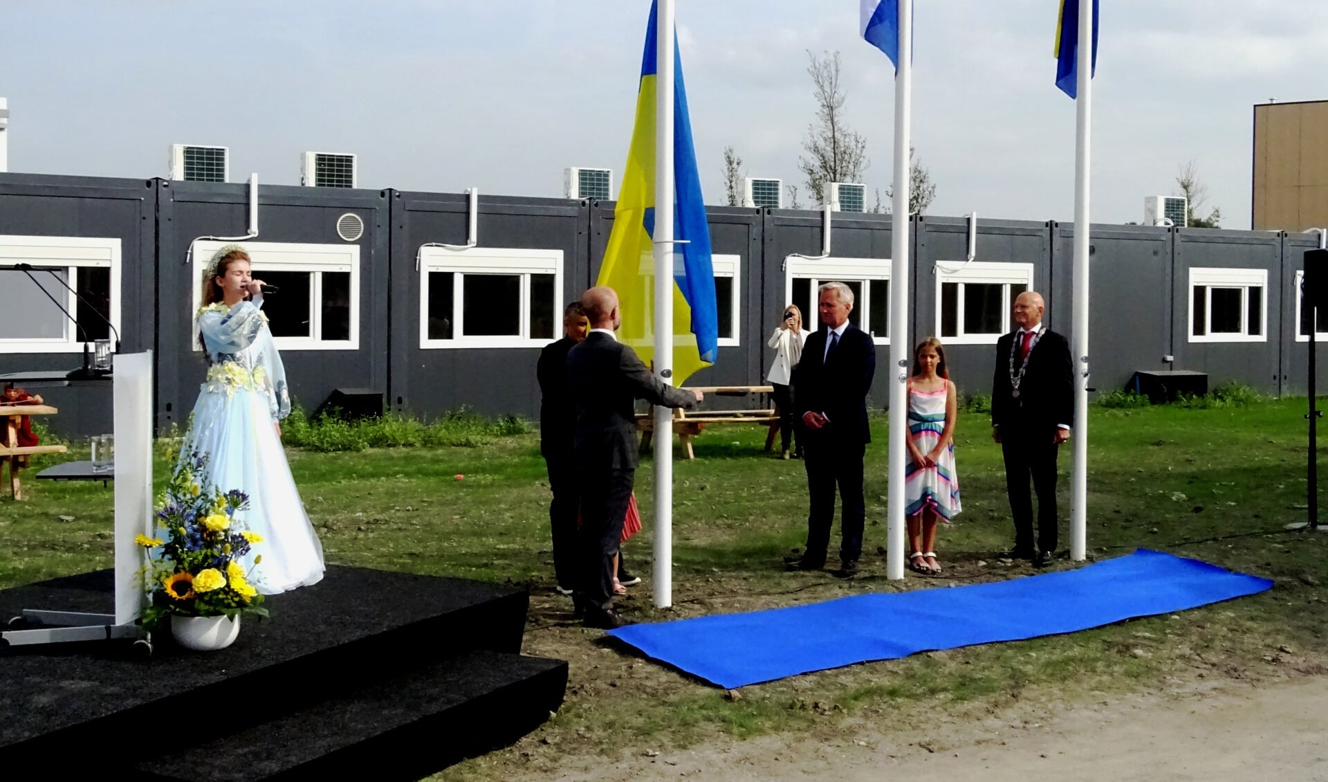 Terwijl de Oekraïense ambassadeur Oleksandr Karasevychen de blauw gele vlag van zijn land hijst zingt Veronika Morska het volkslied. Burgemeester Bert Wijbenga en demissionair staatssecretaris Eric van der Burg kijken toe..