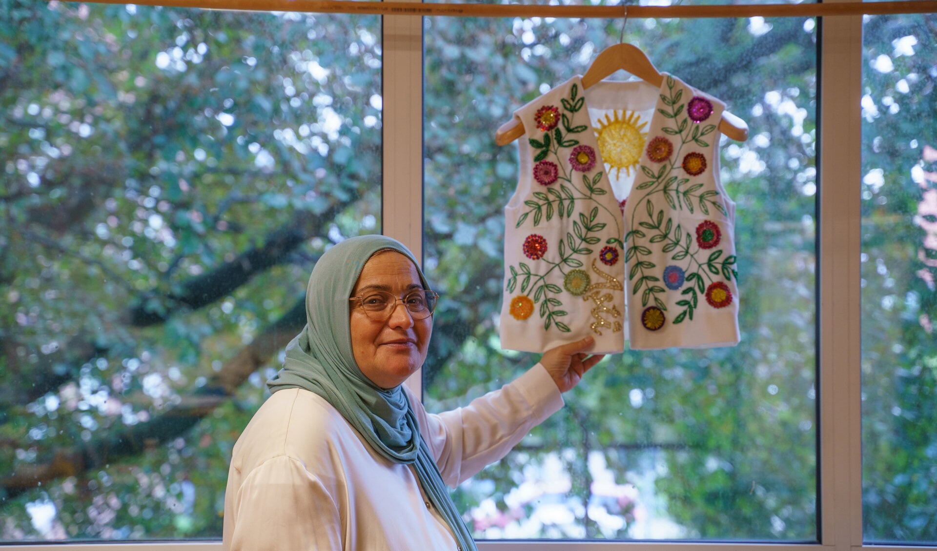 Tara laat trots het geborduurde jasje zien dat voorzien is van verschillende symbolische motieven uit haar thuisland Koerdistan.