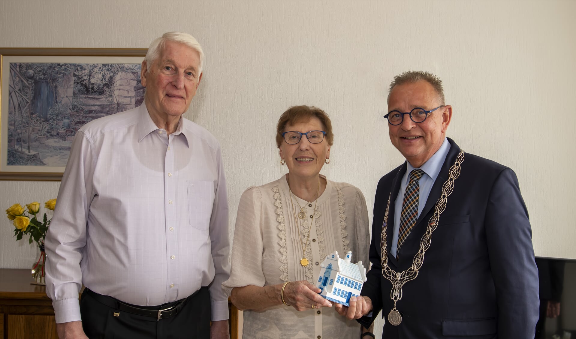 Jules Bijl overhandigt het echtpaar Van Deuzen een miniatuur stadhuis in Schiedams blauw
