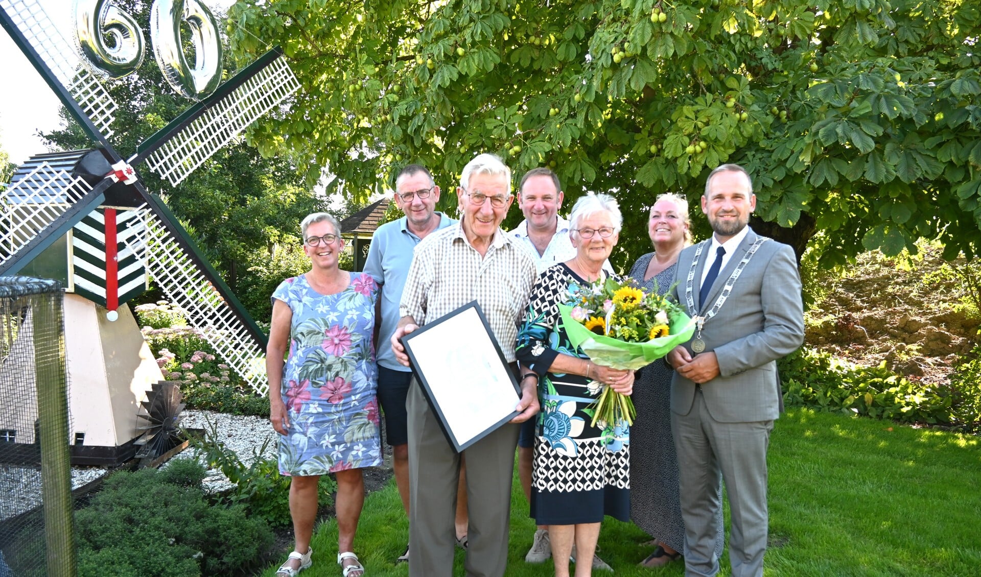 Het diamanten paar samen met de zoons, schoondochters en de burgemeester op de foto bij de molen in de mooie voortuin.