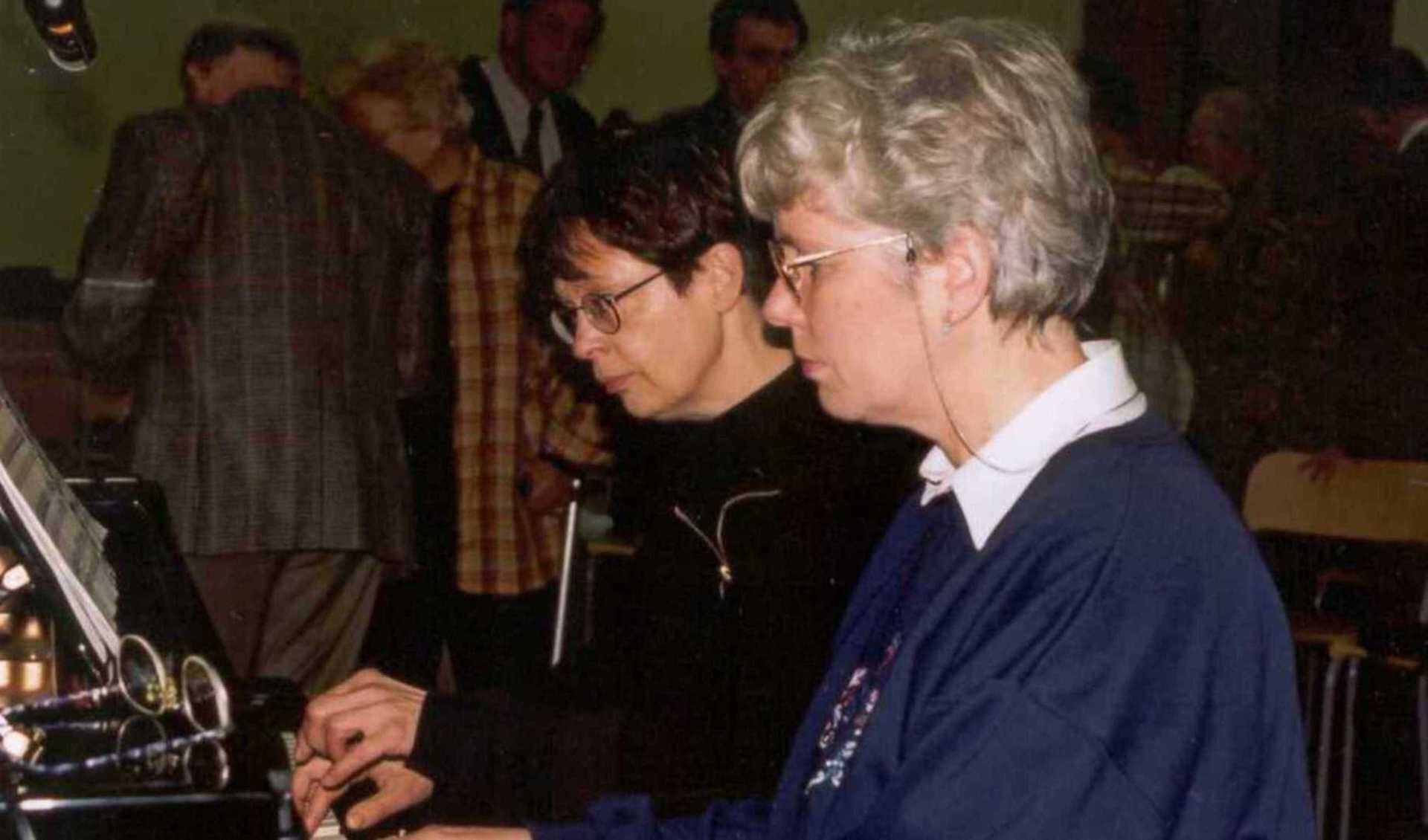 Vier handen op één piano.