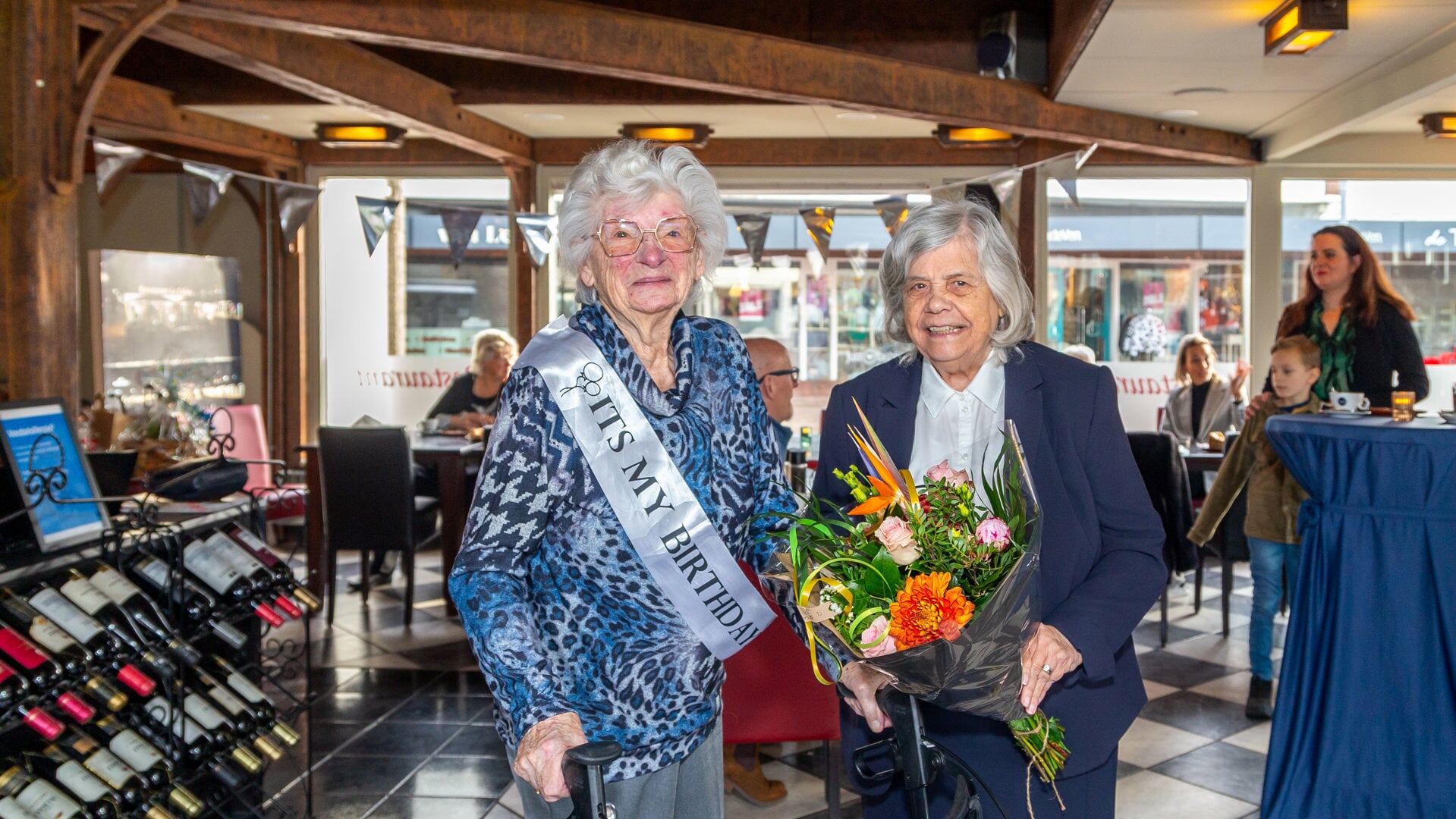 Ze is 104 geworden. Rens Wolfert krijgt bloemen van de dorpsraad uit handen van Ria de Sutter.