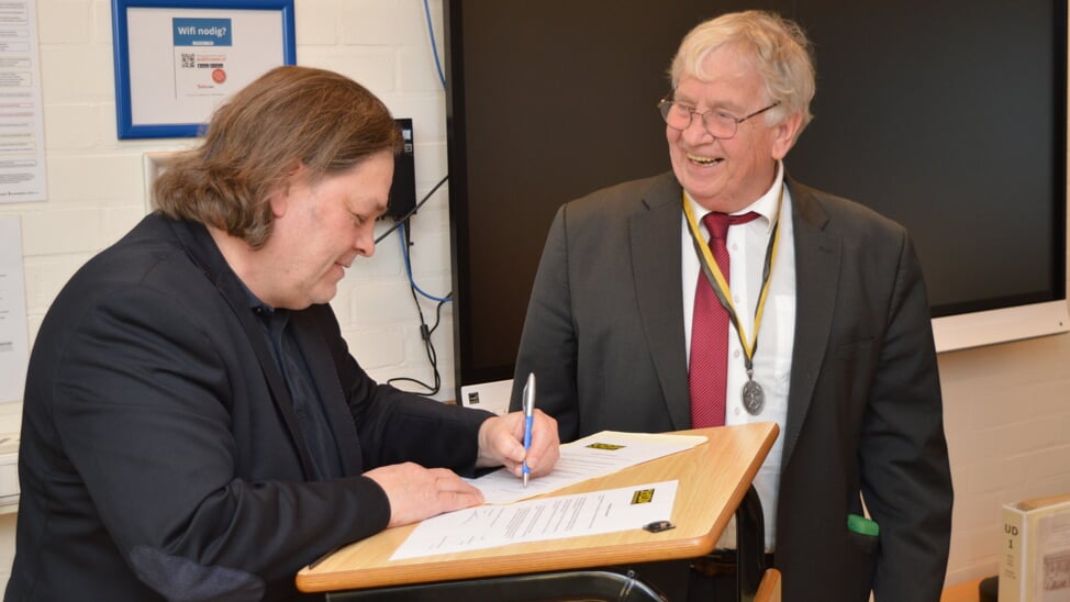 Gemeentearchivaris Laurens Priester en voorzitter Tom Hecker tekenen voor de overdracht van het archief van Utile Dulci.