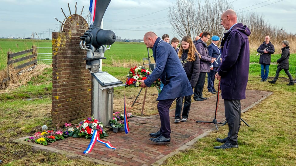 Burgemeester Nieuwland legt namens gemeenten Uitgeest en Heemskerk onder toeziend oog van burgemeester Luijten van Heemskerk en kinderburgemeester Vesper Snijder bloemen bij het monument.