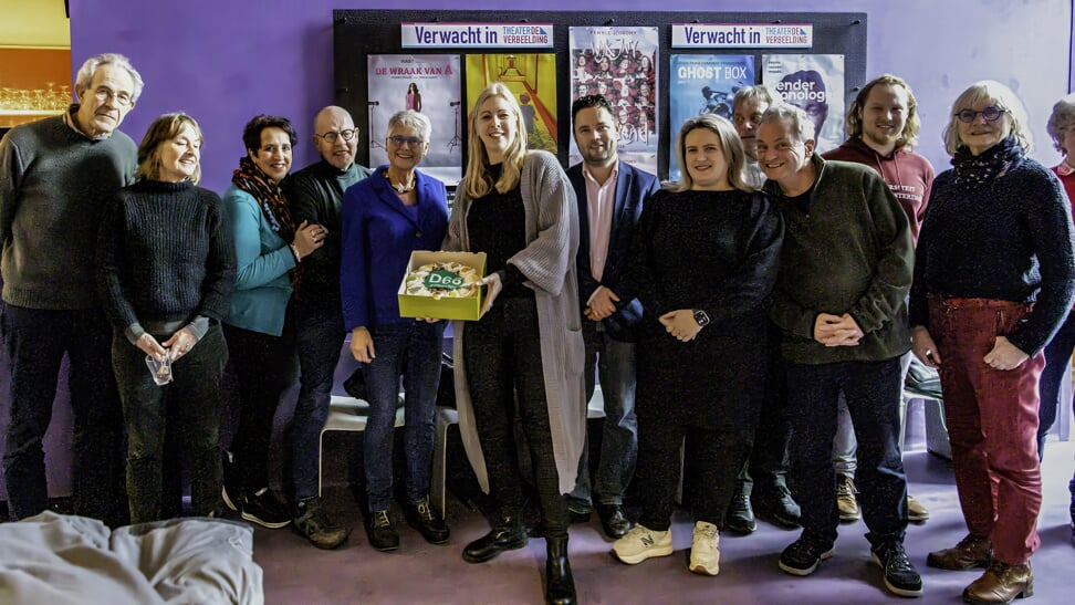Omringd door leden van D66 en vrijwilligers van De Verbeelding toont Astrud Wildschut de taart.