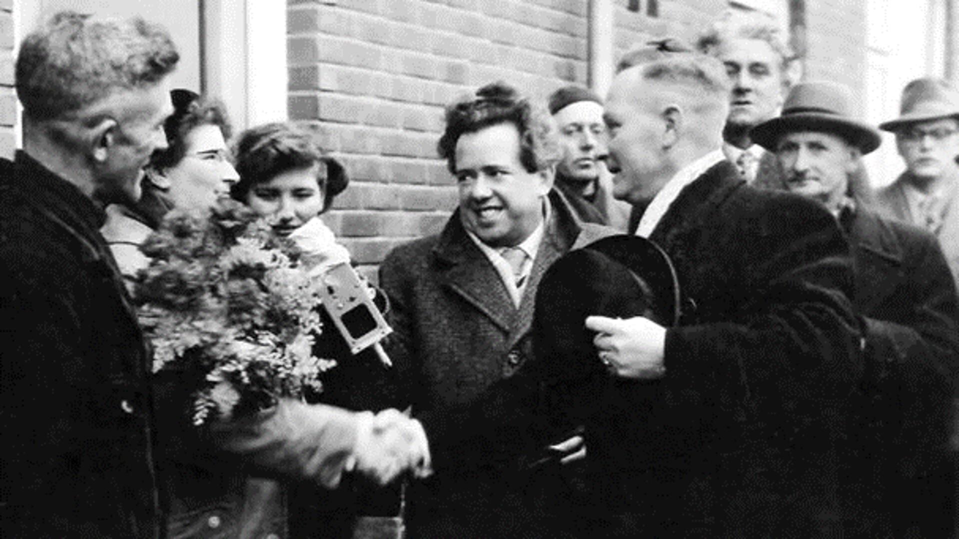 21 januari 1957. Burgemeester Fokko Omta overhandigt de sleutel aan familie Feenstra. 