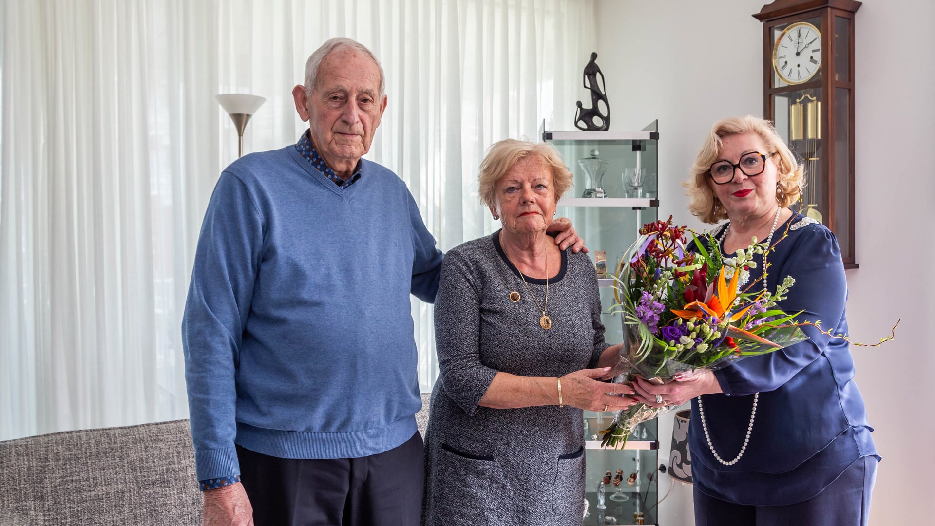 Wim en Sjanie van Heijzen ontvangen bloemen van de dorpsraad uit handen van Vanja Beukelman. 