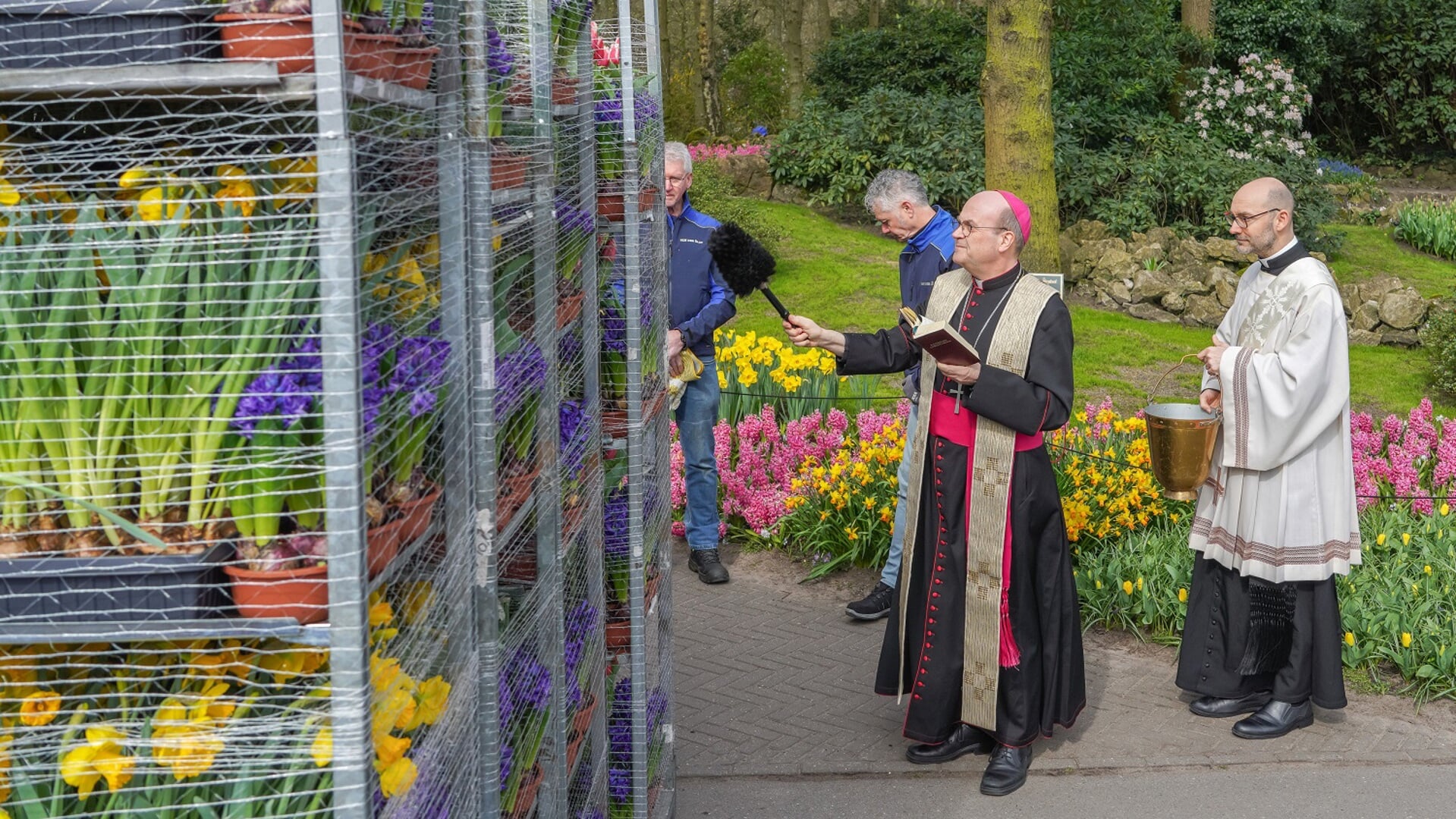 Mgr. Van den Hende, bisschop van Rotterdam, zegent de bloemen, waaronder ook Westlandse, voor het vertrek. 