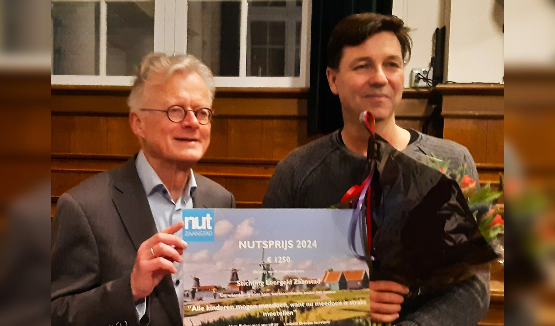Hans Luiten (r), voorzitter van Stichting Leergeld Zaanstad, neemt de Nutsprijs 2024 in ontvangst van Hans Pielkenrood, voorzitter van Nut Zaanstad.