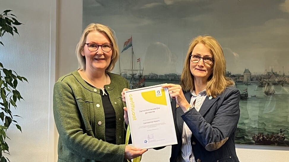 Overhandiging certificaat door Tineke Kunst (r), voorzitter Alzheimer West-Friesland, aan wethouder Van der Ven.