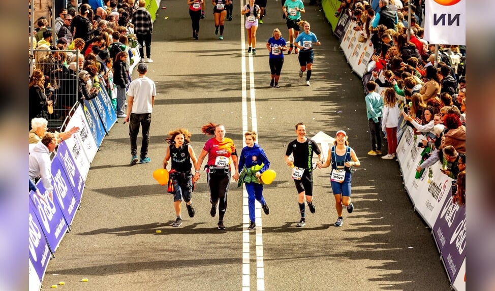 Yaro, links van zijn moeder Judith, en Jesse lopen het laatste stuk van de Marathon Rotterdam met Judith mee.