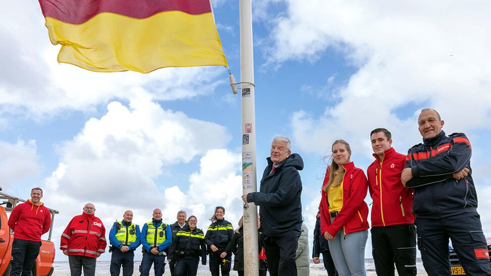 Burgemeester Jan van Zanen hijst de rood-gele vlag. 