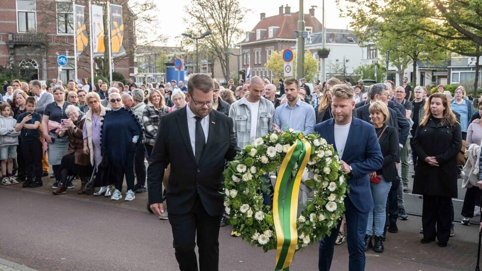 Twee raadsleden leggen een krans tijdens de herdenking in 2023 bij het monument in Loosduinen. 